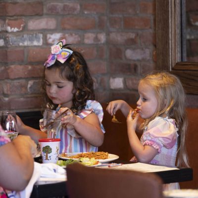Two small girls enjoying spaghetti dinner at Valentina's restaurant at Bridge Park in Dublin, Ohio.