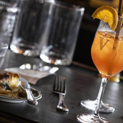 Close up of orange cocktail with orange slice garnishes at Valentina's restaurant in Dublin, Ohio at Bridge Park.