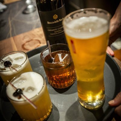 A tray of cocktails, beer, and a bottle of wine at Valentina's Italian