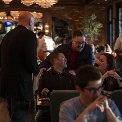 A host at Valentina's Italian brings guests to their table