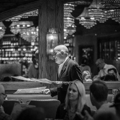 A host at Valentina's Italian brings guests to their table