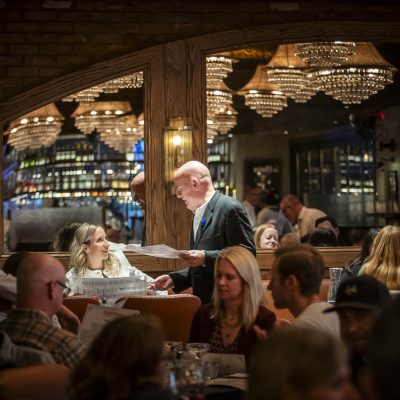 A host at Valentina's Italian brings guests to their table