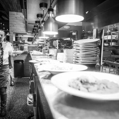 Servers pick up dishes from the expo line at Valentina's Italian