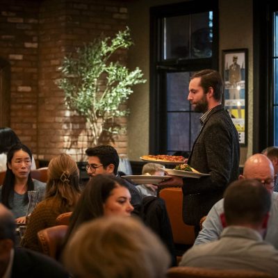 A server at Valentina's delivers food to guests in the dining room