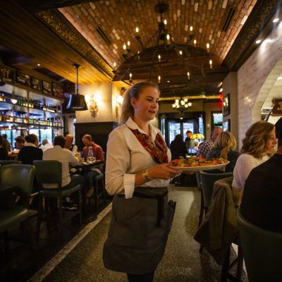 A server at Valentina's delivers food to guests in the dining room