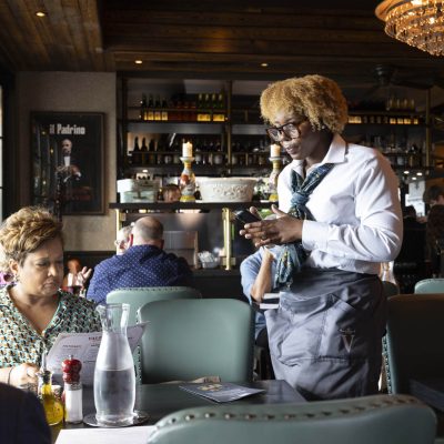 Server taking order from guests in dining room at Valentina's restaurant in Dublin, Ohio at Bridge Park.