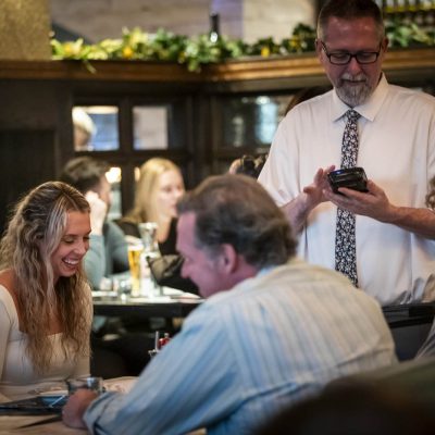 A server at Valentina's takes the orders of three guests