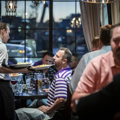 A server at Valentina's delivers food to a table