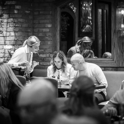 A server at Valentina's takes the orders of two guests