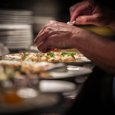 One of the chef's at Valentina's Italian garnishes plates before their sent out