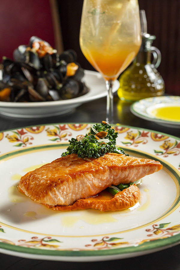 Salmon with toasted garlic broccolini and red chili pesto with cocktail served at Valentina's Restaurant, Bar and Pizzeria in Bridge Park, Dublin, Ohio.
